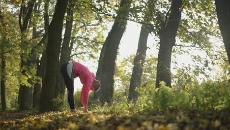 mujer estirándose en el parque de otoño