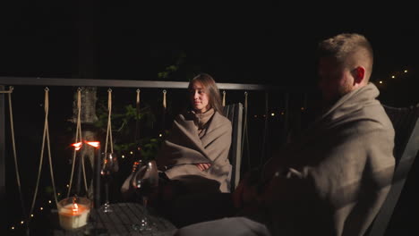 couple enjoying a romantic dinner on a balcony at night