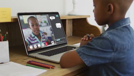 Colegial-Usando-Una-Computadora-Portátil-Para-Clases-En-Línea-En-Casa,-Con-Su-Colega-Y-Chat-Web-En-Pantalla