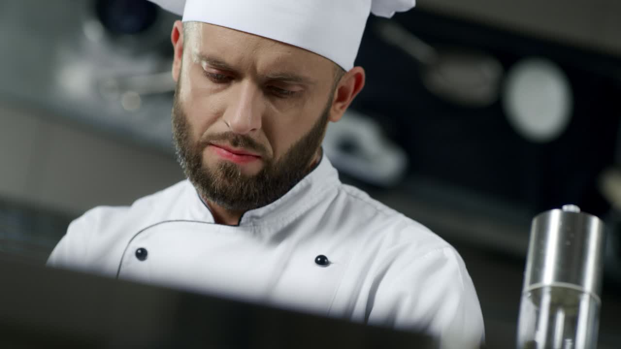 retrato de un chef en una cocina profesional. chef cocinando comida en cámara lenta