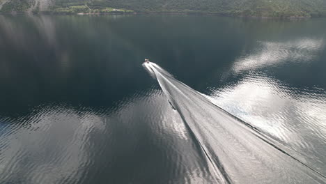 boat-sailing-a-fjord-lake-with-reflection-of-clouds,-Eikesdalsvatnet,-Eikesdalen,-norway