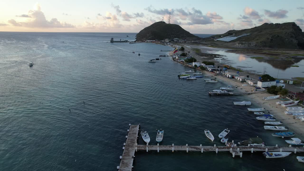 해가 지는 그란 로크 해변의 공중 뒷면 사진, 배와 조용한 해안 진동