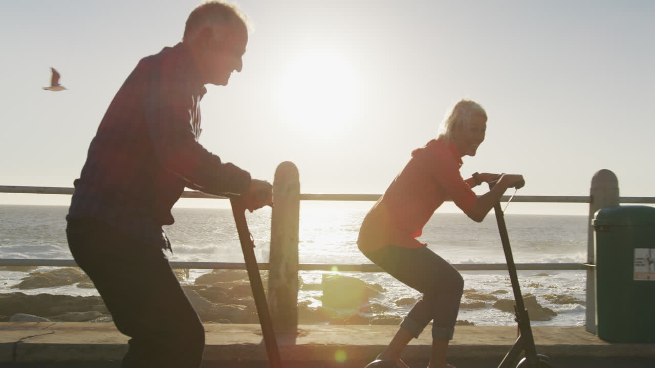 ein älteres paar, das elektrische roller am strand benutzt