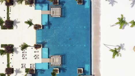 aerial top down view directly above blue swimming pool of tropical resort, dominican republic