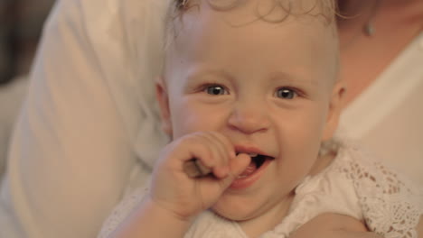 smiling baby girl with clothespin in the mouth