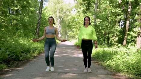 fit women doing jumping jacks in the park