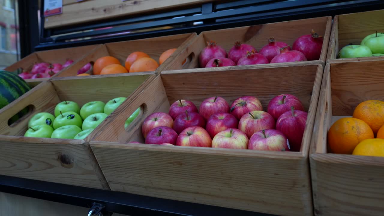 Fresh fruit display with apples, oranges, and other produce at a farmers market