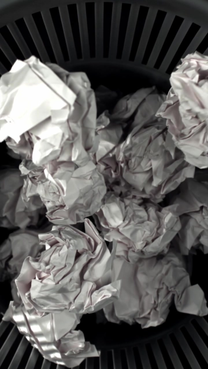 Crumpled Paper Falling into a Trash Can in Slow Motion