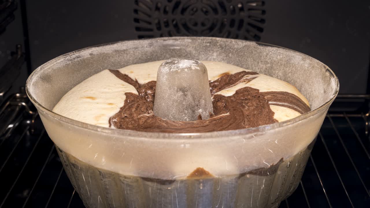 유리 모형에서 전통적이고 맛있는 트 케이크를 는 것: 양식의 가장자리 위로 천천히 상승하는 페이스트리, 집에서 만든 스폰지 대리석 케이크, 오븐의 앞면, 타임 스 비디오