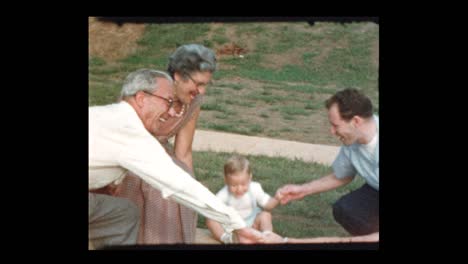 family plays ring around the rosie with baby boy