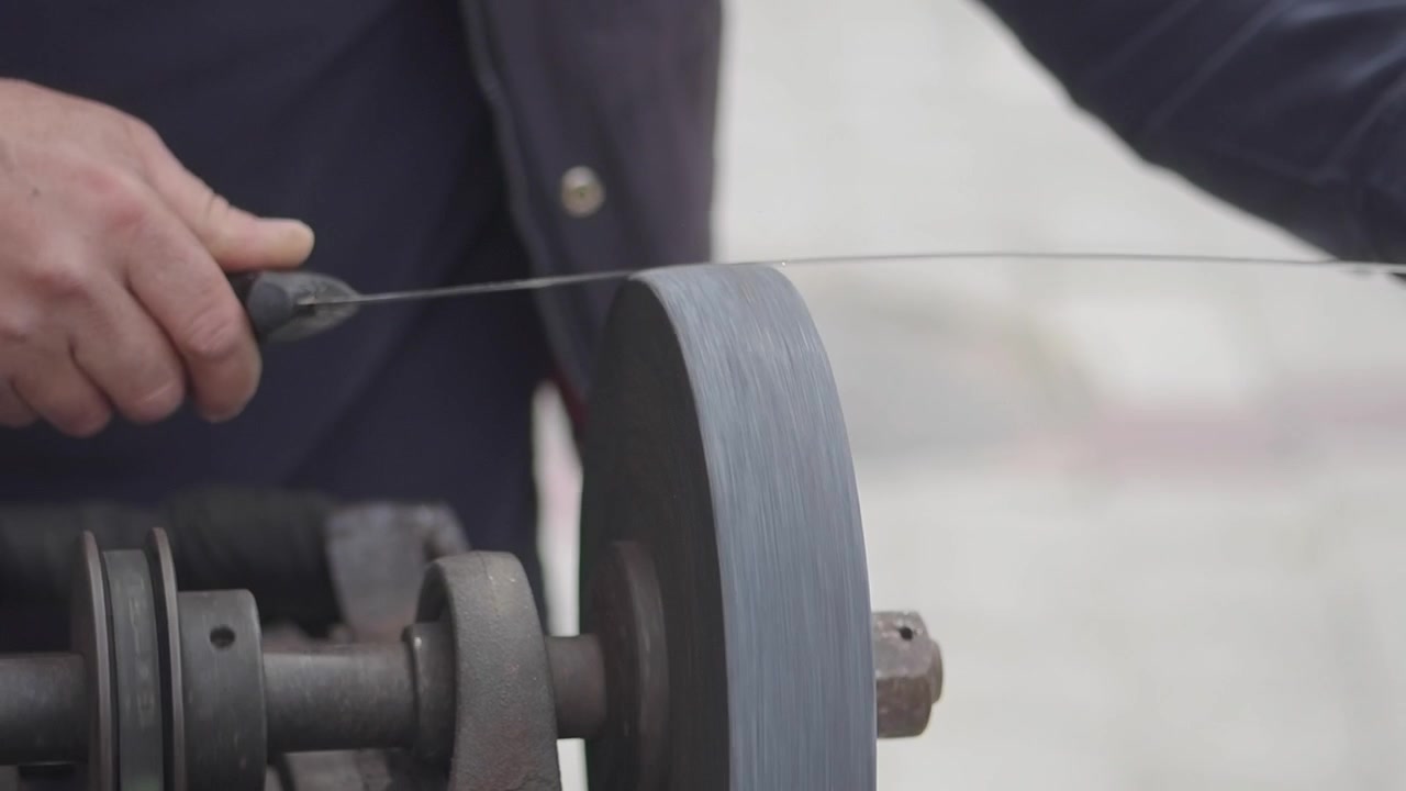 Close-up of a Person Sharpening a Knife on a Grinding Wheel