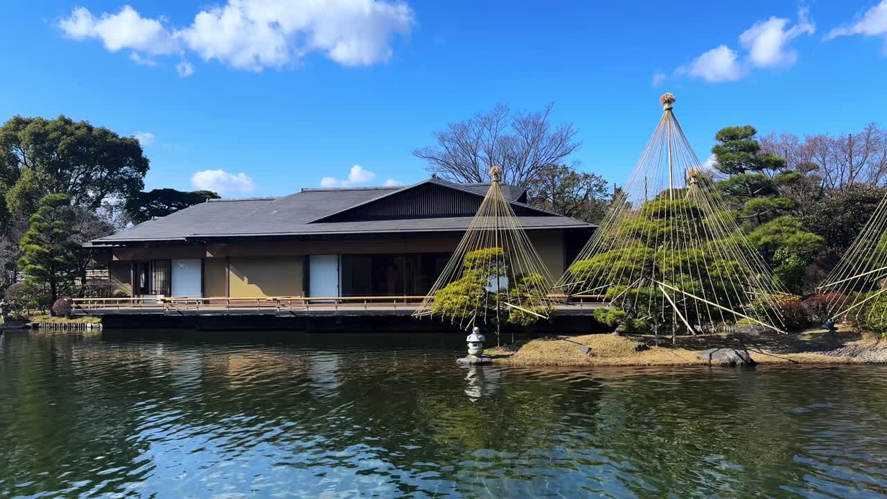 A traditional Japanese garden with a scenic view of the house and trees by the water