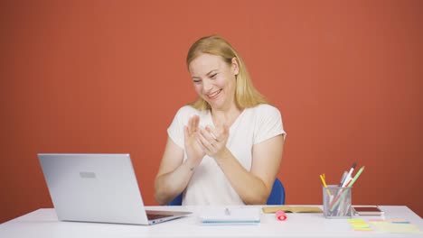 woman looking at laptop applauding.