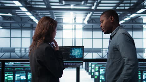 Programmers coding on laptop using artificial intelligence in server farm