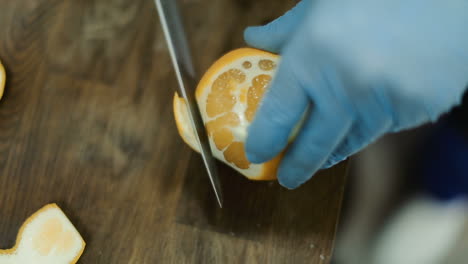 las manos del chef cortando naranjas.