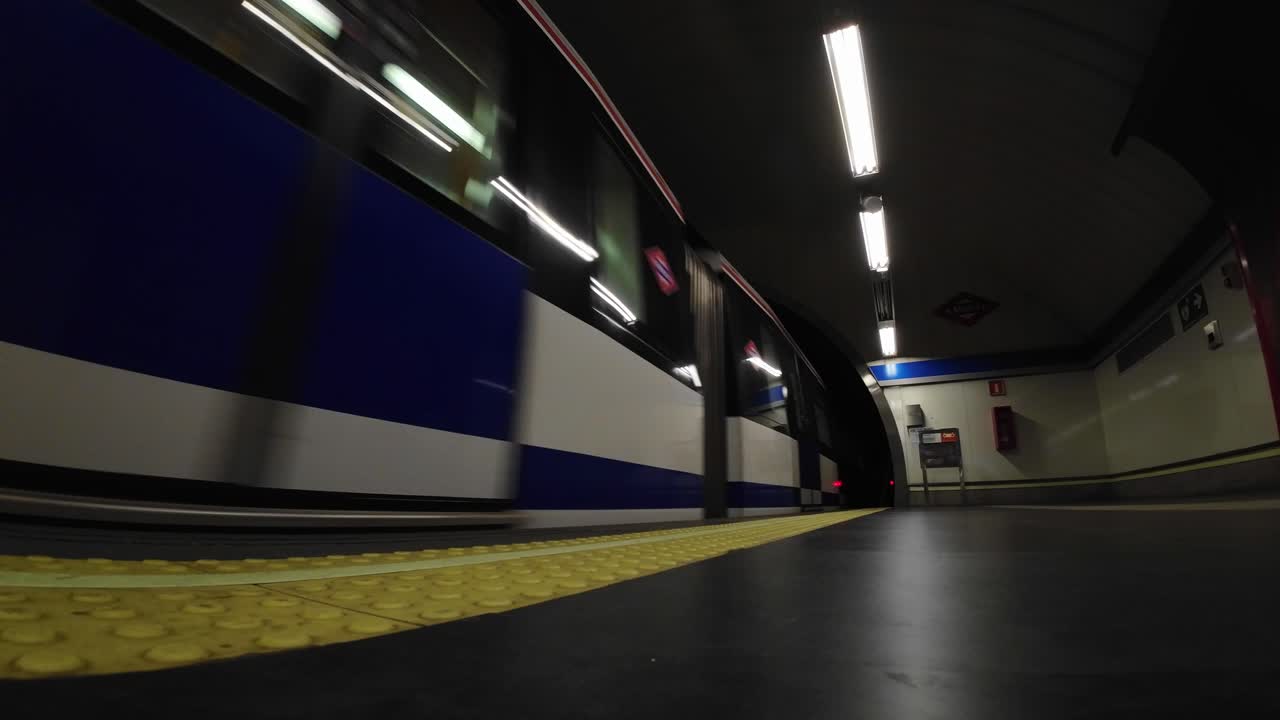 Treno della metropolitana che arriva e attraversa una stazione sotterranea vuota