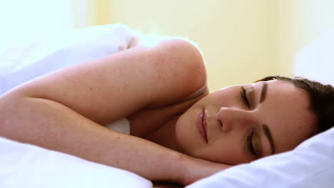una mujer hermosa durmiendo en la cama.