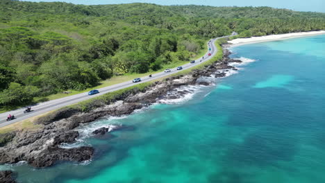 aerial view of a coastal road winding along a tropical island shoreline
