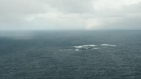 Moody-cloudscape-over-seascape,-aerial-view