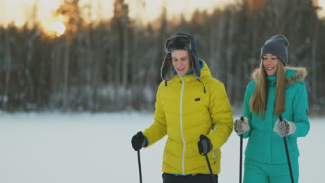 look at each other with loving eyes while skiing in the winter forest. a married couple practices a healthy lifestyle