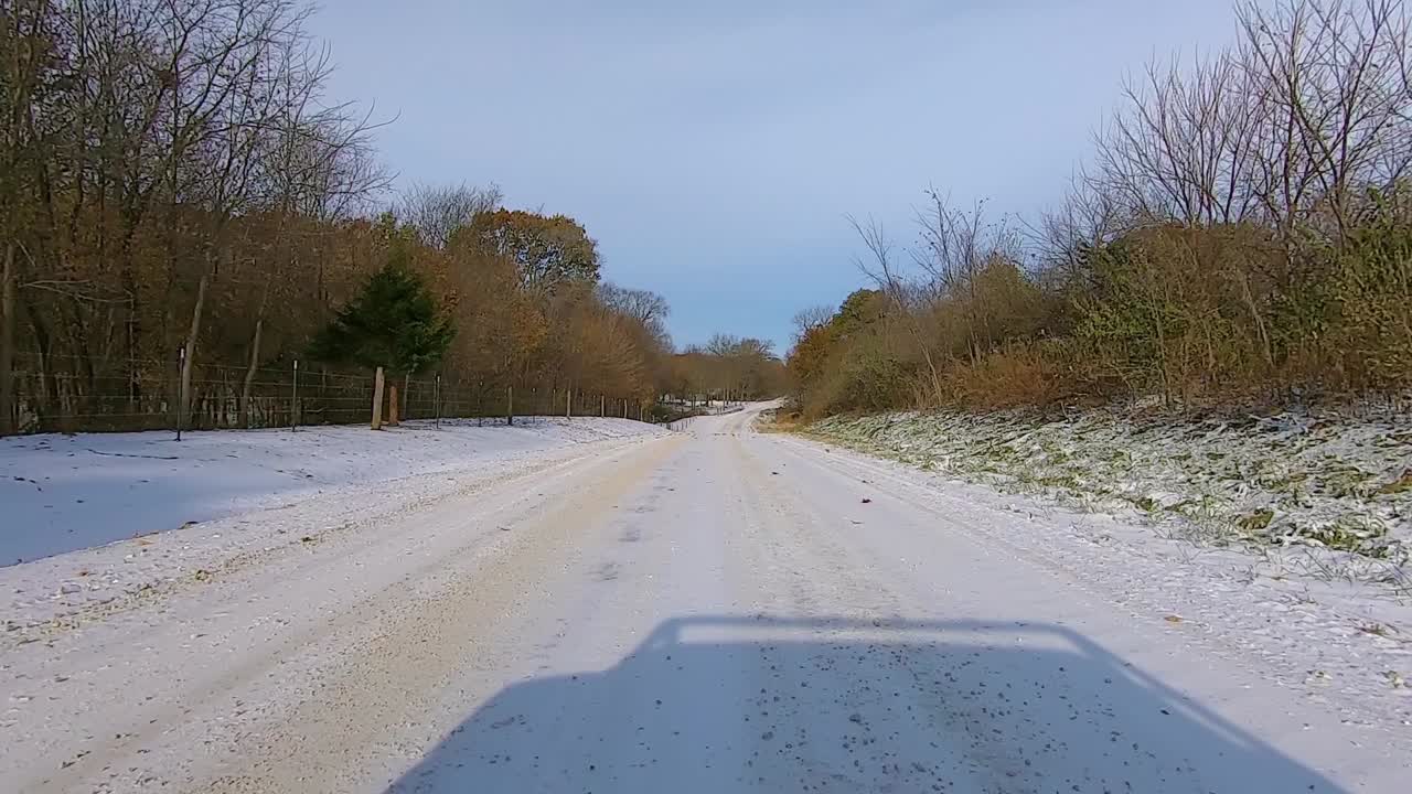 이른 겨울 오후에 목재와 농가를 지나 시골 눈 덮인 도로를 운전하는 동안 뒷창을 통해 pov