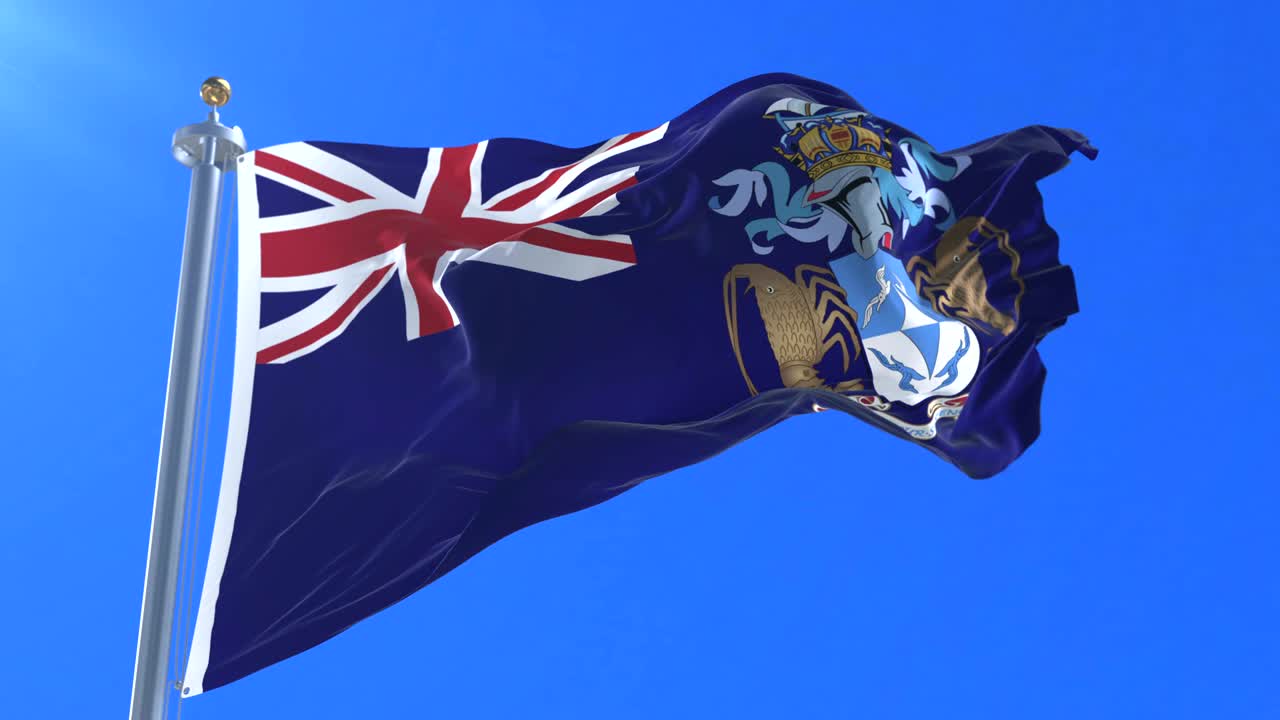 Flag of Tristan da Cunha waving at wind in slow with blue sky, loop