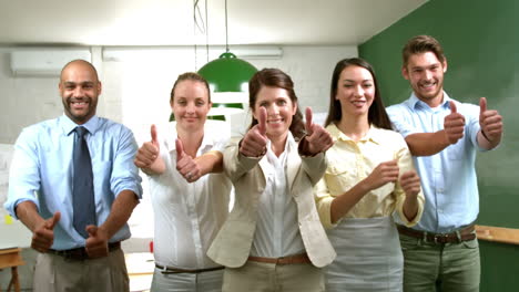 equipo de negocios casual mostrando pulgares hacia la cámara