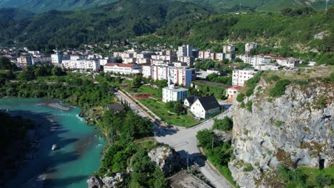 spring morning colors permet city revealed behind majestic rock by turquoise vjosa river panorama