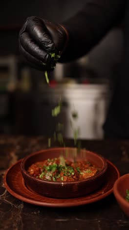 chef adding herbs to a dish