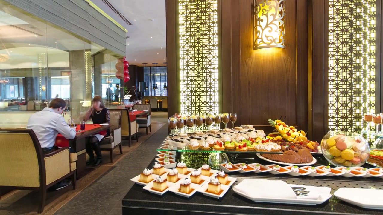 Tavolo da ristorante apparecchiato per il brunch con piatti, stuzzichini, insalate, posate, bicchieri da vino e acqua, timelapse hyperlapse. Buffet di cibo europeo in un ambiente da ristorante. Catering.