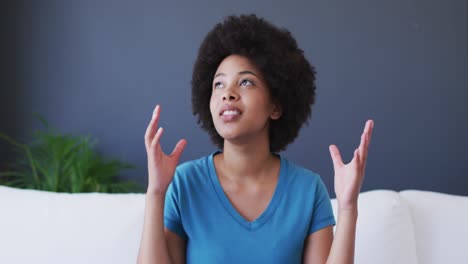 retrato de una mujer afroamericana hablando por videollamada mientras estaba sentada en el sofá en casa
