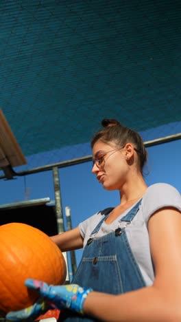 mujer cosechando calabazas