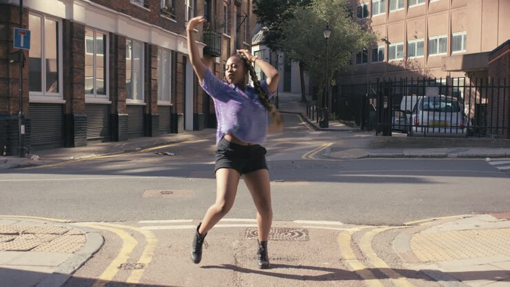 Contemporary funky African American woman street dancer dancing freestyle in the city