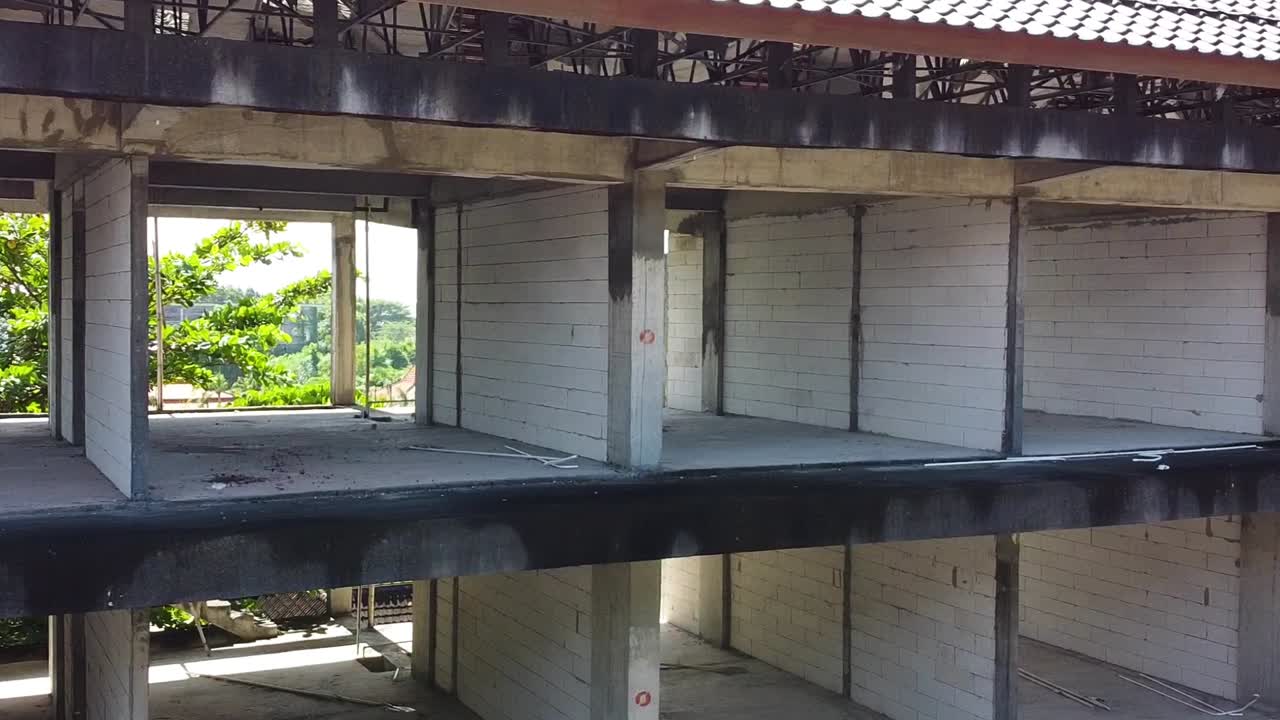 무인 항공기는 호텔 방을 통해 발리 해변에서 버려진 호텔을 보여줍니다.