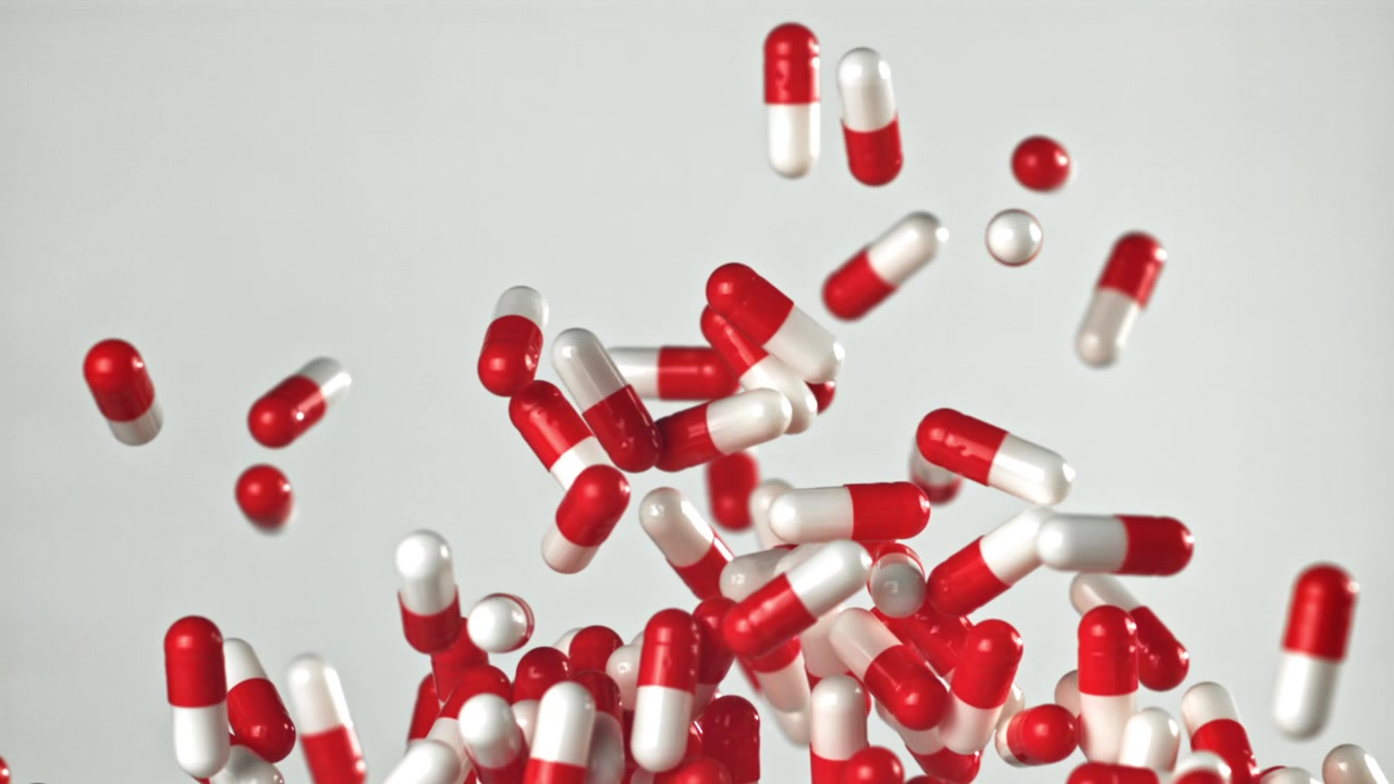 Caduta al rallentatore di capsule di medicinale rosse e bianche
