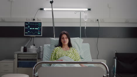 paciente con tubo de oxígeno nasal mirando a la cámara sentado en la cama
