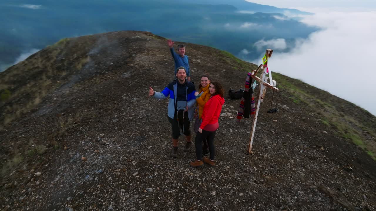 A hiking group of four friends celebrates reaching the top of the Paricutin Volcano caldera in Michoacan, Mexico. A thrilling adventure amidst breathtaking volcanic scenery.