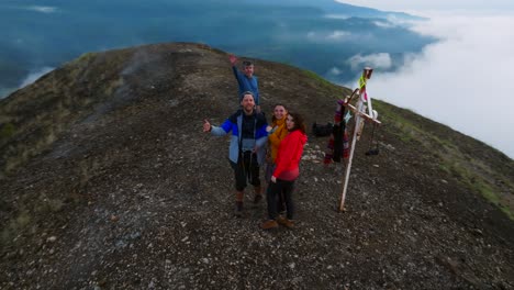 un grupo de excursionistas de cuatro amigos celebra haber llegado a la cima de la caldera del volcán paricutin en michoacán, méxico. una emocionante aventura en medio de un impresionante paisaje volcánico.