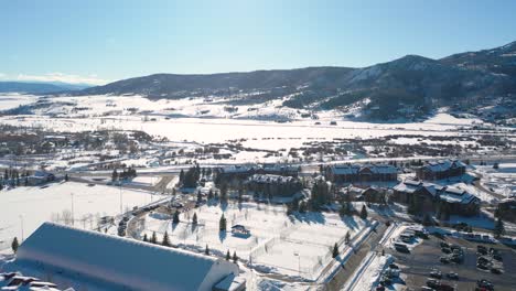 snowy rooftops and tranquil winter mountain scenery in colorado - aerial drone pan right