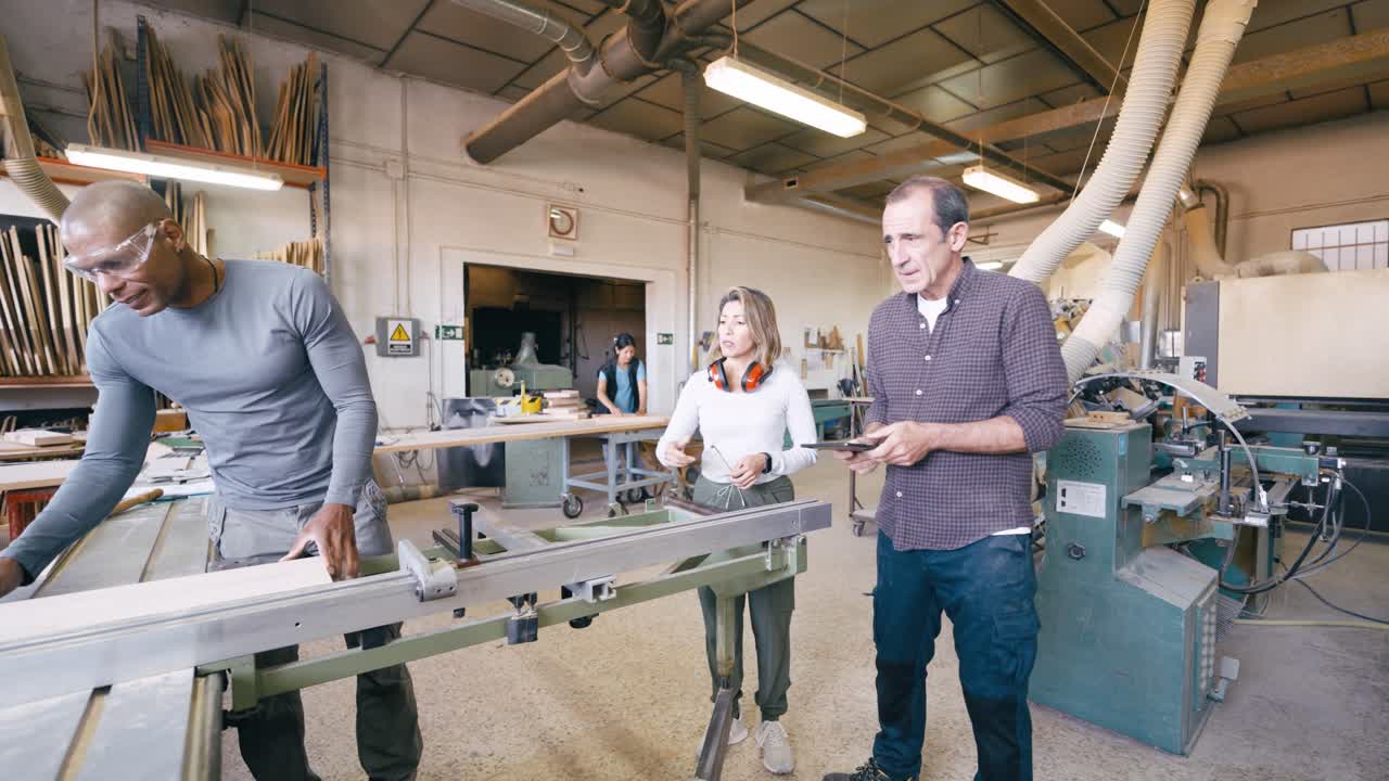 Diverse Team of Woodworkers Collaborating in a Busy Workshop