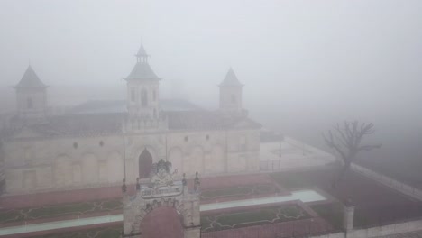 drone flying over chateau cos d'estournel winery on foggy day, bordeaux region of france
