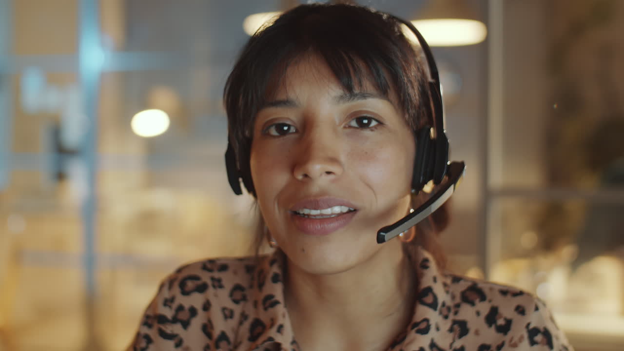 Hispanic Businesswoman in Headset Talking on Camera in Night Office