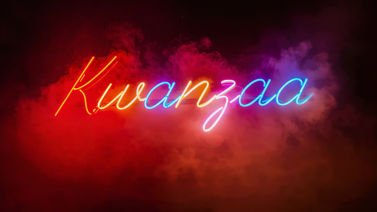 Insegna al neon pulsante con la scritta Kwanzaa che cambia tonalità sul palco, luci che cambiano e macchina del fumo in funzione