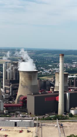 aerial view of the fossil fuel energy industry, climate change, heavy industry, chimney, water towers.vertical video