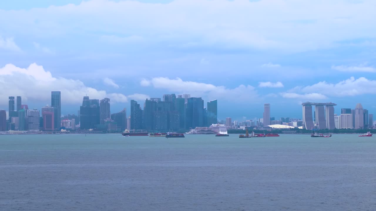 港に停泊した船から見た、夕暮れのシンガポールのスカイラインの広角パンニングショット。