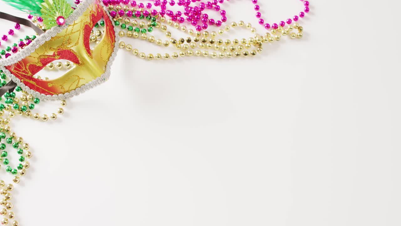 코피 스페이스와 함께  ⁇  배경에 금 마스케레이드 마스크와 마디 그라 구슬의 비디오