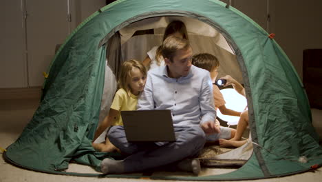 Father-teaching-kids-with-flashlight-to-be-scouts