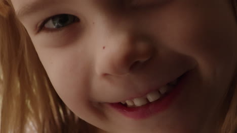 Sweet-close-up-portrait-of-a-happy,-smiling-little-girl-wiggling-her-loose-tooth