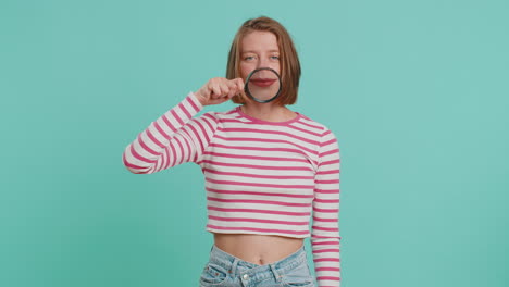 Woman-holding-magnifier-glass-loupe-on-teeth,-looking-at-camera-showing-funny-smiling-face-mouth