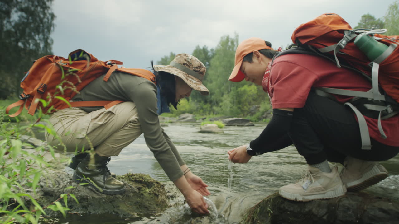 Asian Female Tourists Washing Hands in River